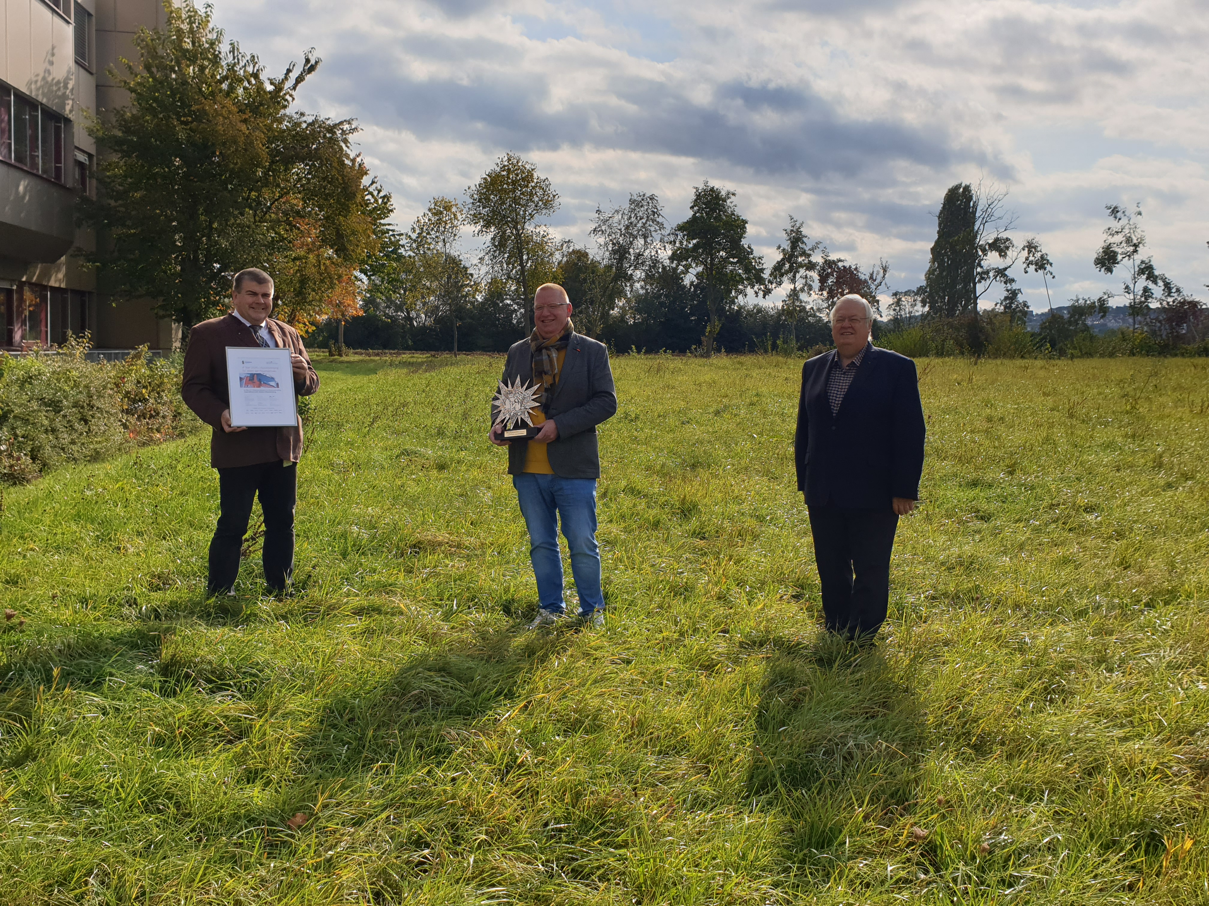 übergabe einer Auszeichnung auf einer grünen Wiese